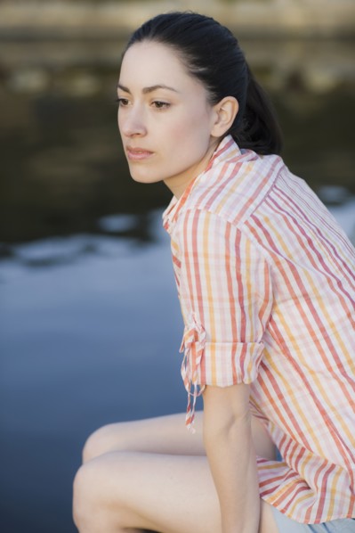A woman sitting by water