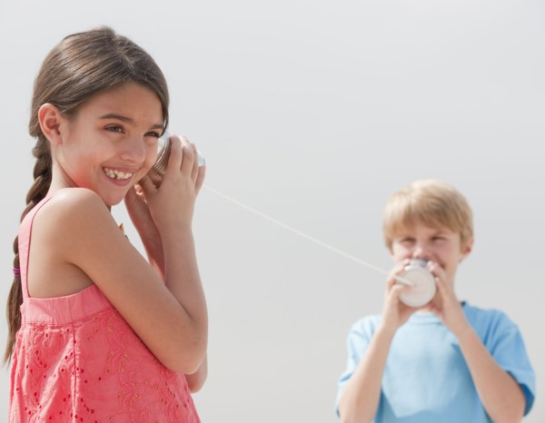 Children playing with a tin can telephone.