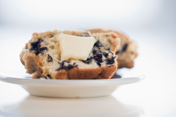 A blueberry muffin with butter.