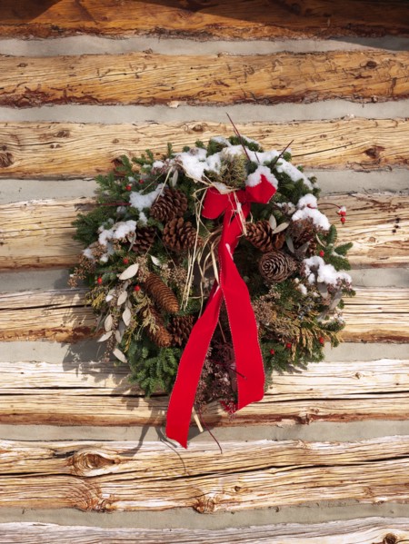 A Christmas wreath on a cabin wall