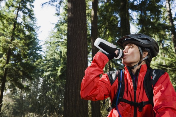 Biker in the woods drinking water