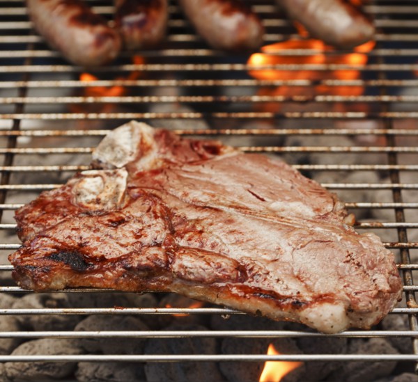 Steak and sausages on a barbeque