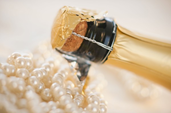 Champagne bottle and pearl necklace.