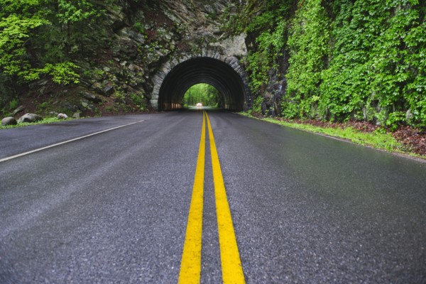A scenic and empty road with tunnel.