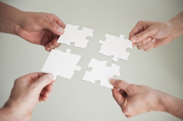 Hands holding puzzle pieces.