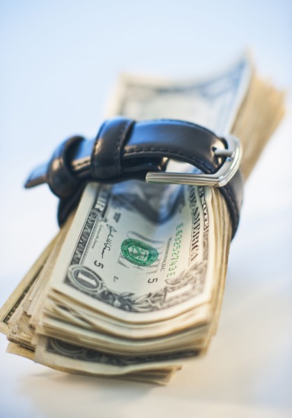 A watch around a stack of money.