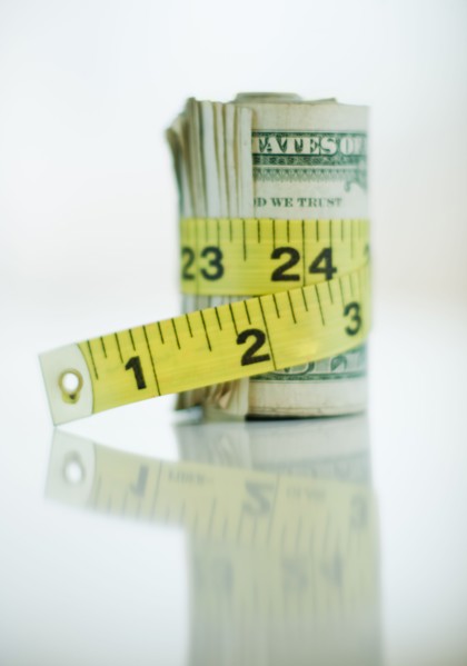 A measuring tape around bank notes.