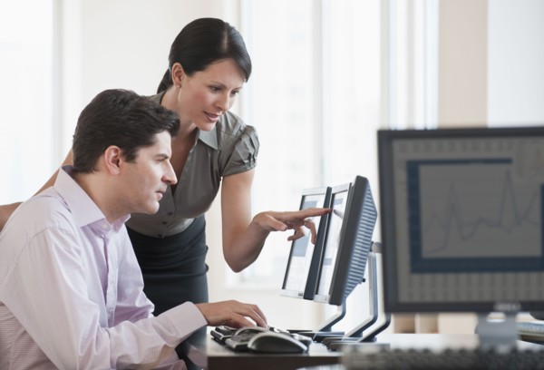 Two business people using a computer.