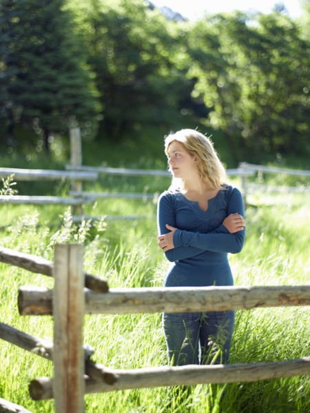 Young woman behind fence