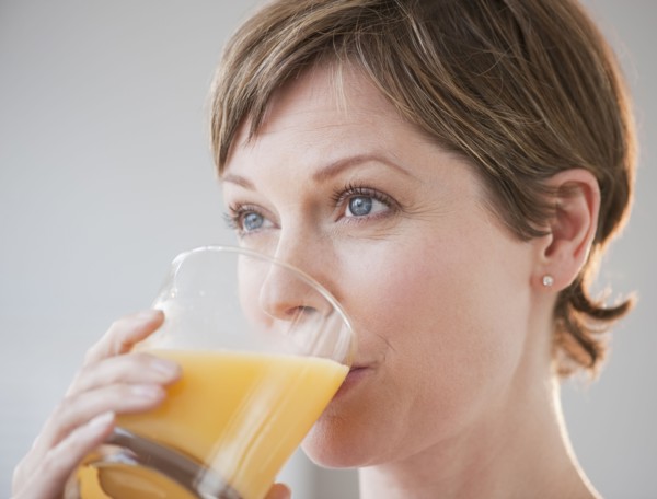 Woman drinking orange juice.