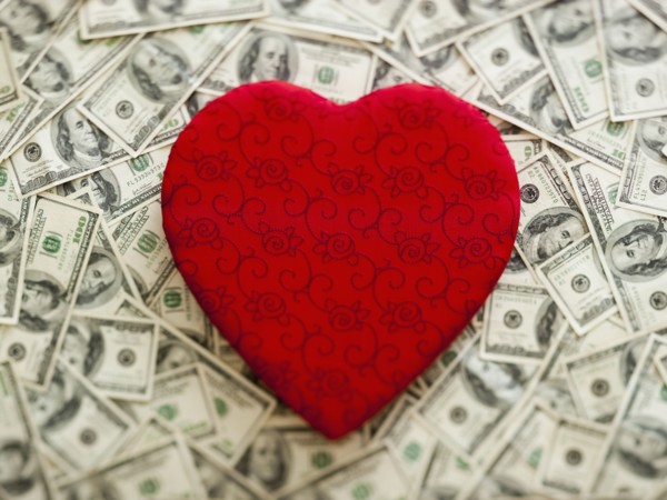 Symbolic red heart wtih US dollars as background