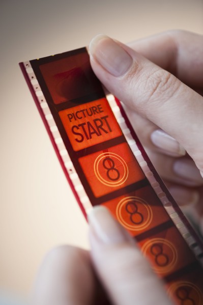 hands holding film strip.