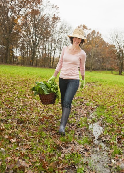 Woman walking with basket of vegetables.