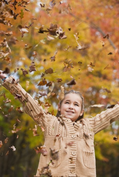 Girl throwing leaves.