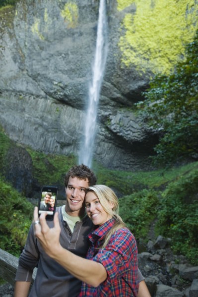 Couple taking picture in front of waterfall