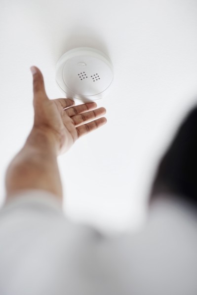 Testing battery in smoke detector. Photographer: momentimages