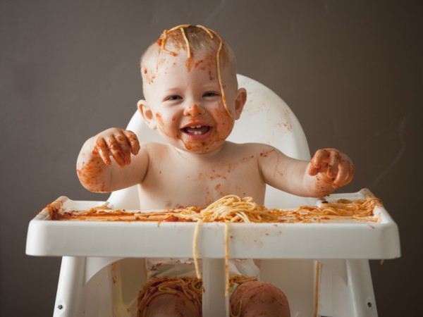 Baby covered in spaghetti. Photographer: Mike Kemp