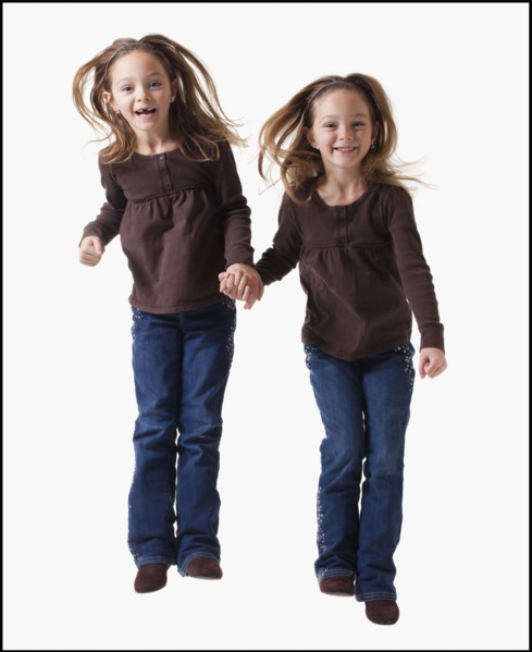 Identical twins jumping. Photographer: Mike Kemp