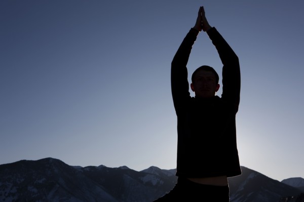 Man doing yoga outdoors. Photographer: Dan Bannister
