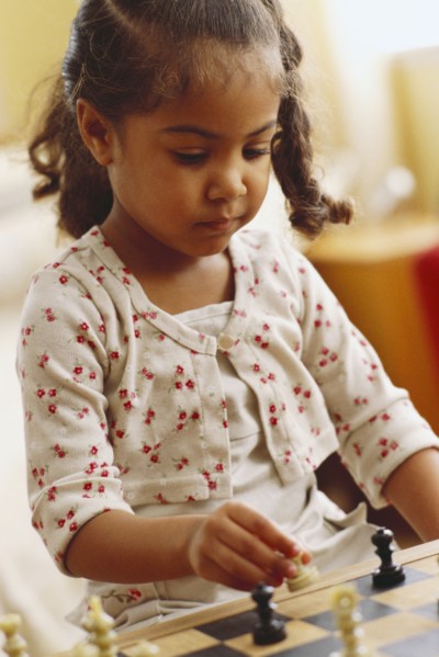 Young girl playing chess. Photographer: Rob Lewine