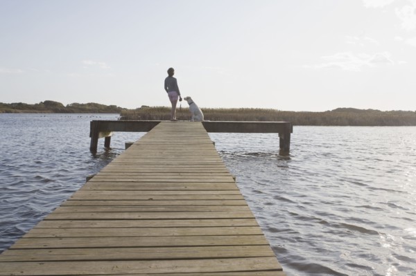 Woman and dog on pier. Photographer: Chris Hackett