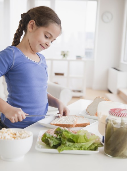 Young girl making sandwich. Photographer: Jamie Grill