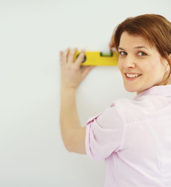 Woman using a level. Photographer: momentimages