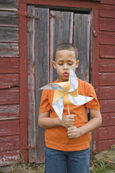 Boy blowing toy windmill. Photographer: Pauline St.Denis