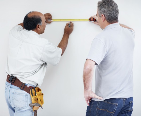 Men measuring wall. Photographer: momentimages