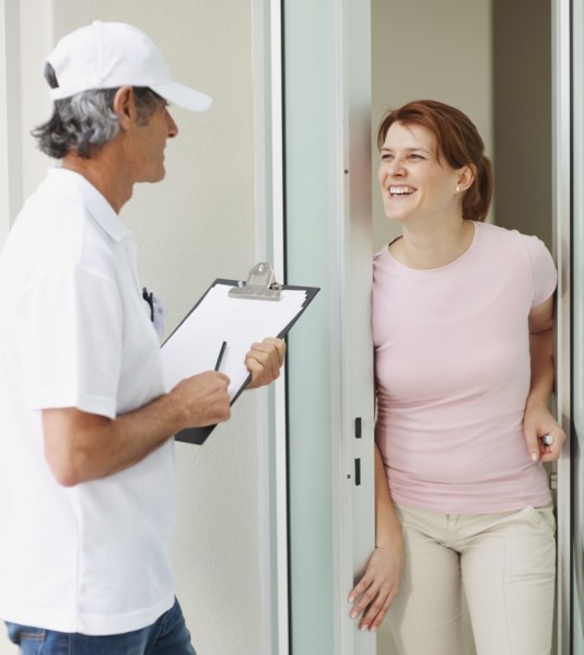 Woman talking to man at the door. Photographer: momentimages
