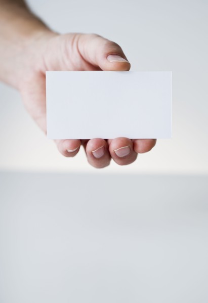 Hand holding white card.