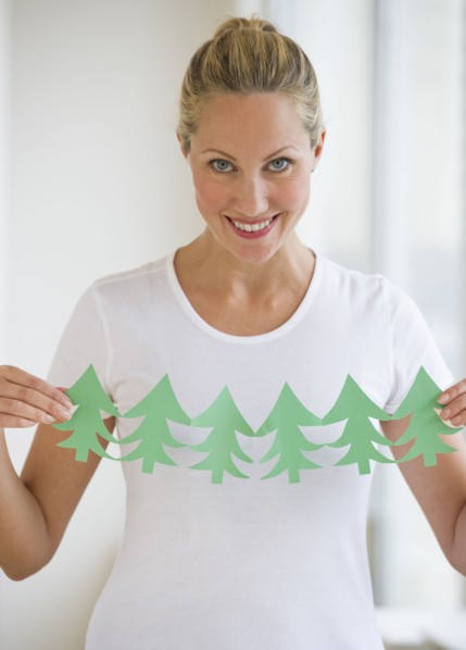 Woman holding cut out of trees.