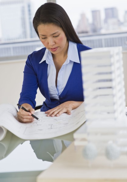 Female architect looking at blueprints.