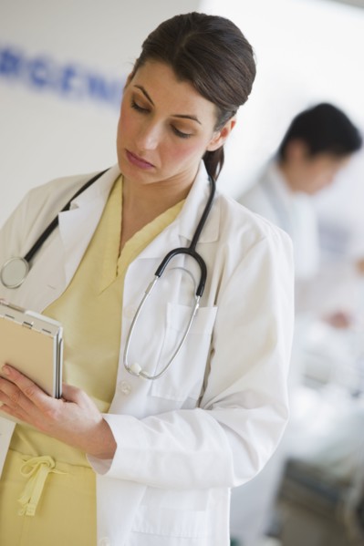 Doctor writing on chart.