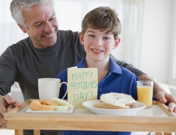Father and son bring mom breakfast in bed. Photographe : Jamie Grill