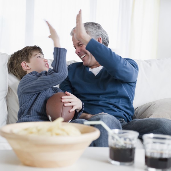 Father and son watching football game. Photographe : Jamie Grill