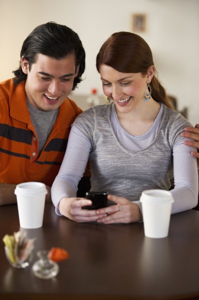 Couple reading text on cellular phone. Photographe : Daniel Grill