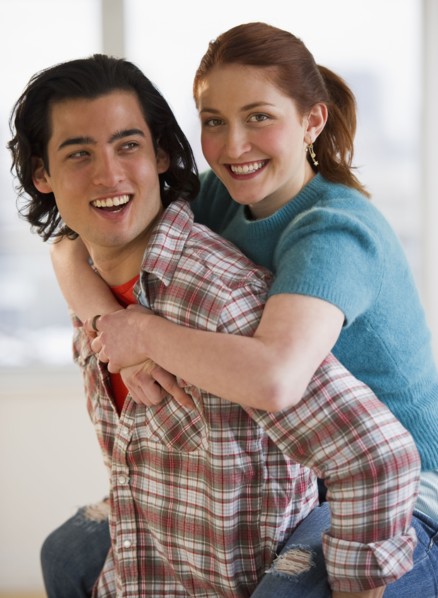 Man giving woman a piggy back ride. Photographe : Daniel Grill