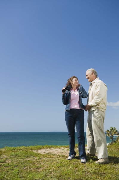Couple looking at ocean with binoculars.