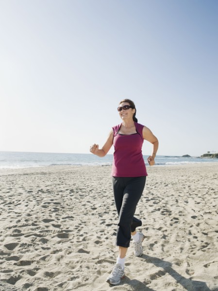 Woman jogging on beach.