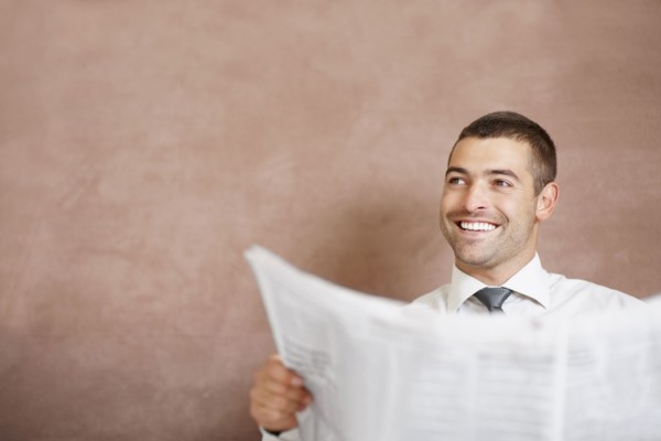 Businessman reading newspaper. Photographe : momentimages