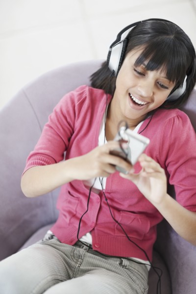 Young girl listening to music. Photographe : momentimages