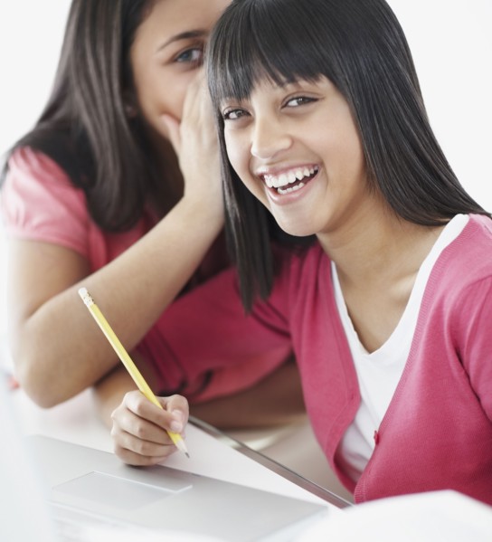 Students whispering in classroom. Photographe : momentimages