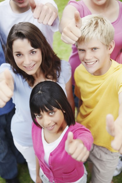 Young friends giving thumbs up. Photographe : momentimages