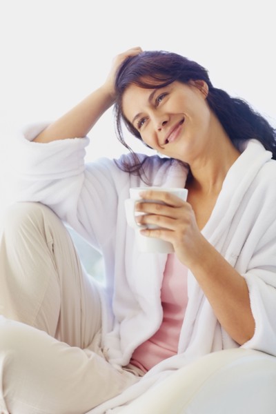 Woman in bathrobe drinking coffee. Photographe : momentimages