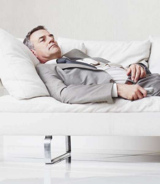 Businessman resting on couch. Photographe : momentimages