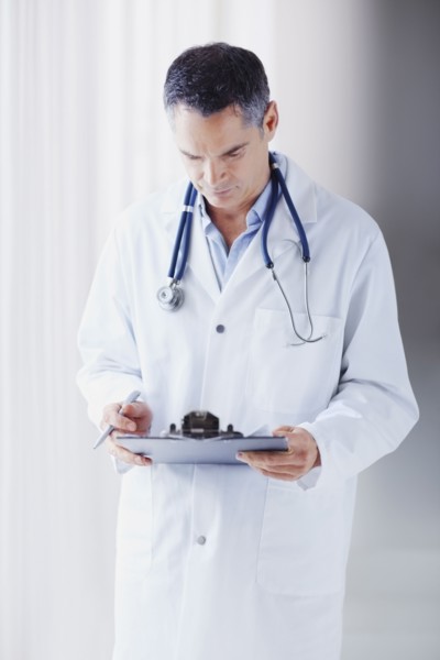 Doctor reading chart. Photographe : momentimages