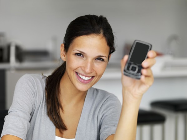 Woman holding cellular phone. Photographe : momentimages