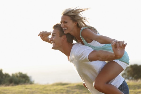 Man giving girlfriend a piggy back ride. Photographe : momentimages