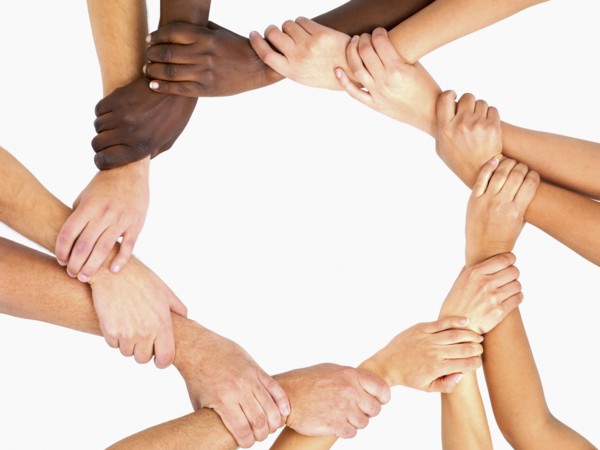 Clasped hands in a circle. Photographe : momentimages